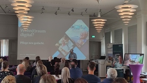 Raum mit Menschen und PowerPoint