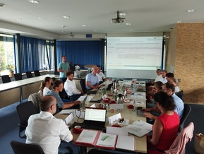 Personen in Besprechungsraum mit Tafel