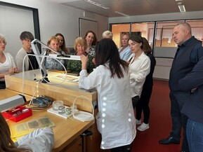 mehrere Personen schauen sich die Fertigung von Uhren an