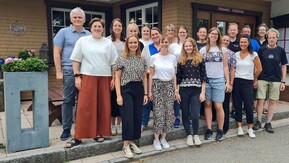 Gruppe von Personen posiert vor Hütte