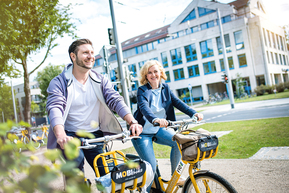 zwei Personen radeln durch die Stadt