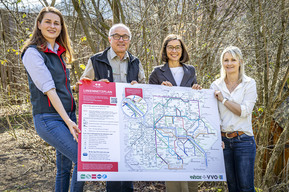 vier Personen mit Schild in Wald