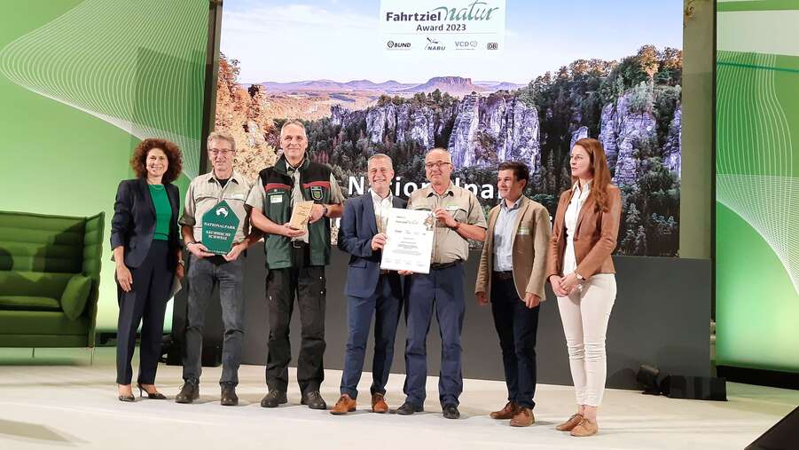 Bundesumweltministerin Steffi Lemke übergab der Trägergruppe Fahrtziel Natur aus der Nationalparkregion Sächsische Schweiz den ersten Preis. Laudatorin war Stefanie Berk (links), Vorständin Marketing und Vertrieb der Deutschen Bahn.