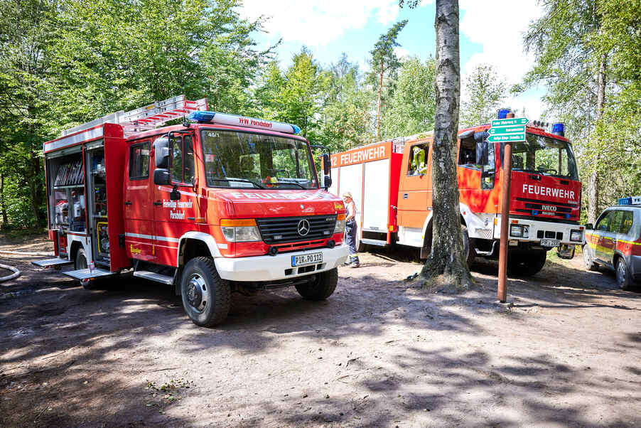 zwei Feuerwehrfahrzeuge im Wald