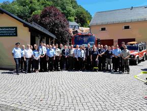 Gruppenbild von Feuerwehrleuten vor einem Feuerwehrauto 