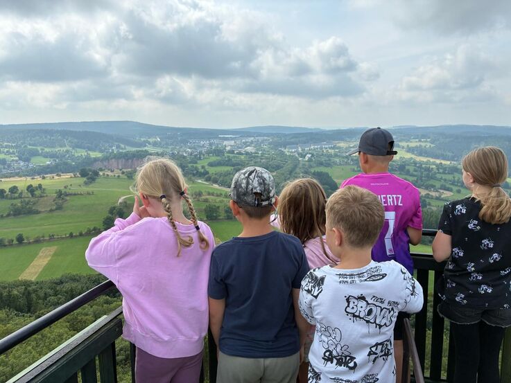 Pflegekinder des LK SOE schauen von einem Berggipfel in die Ferne