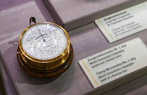 goldenes uhrenähnliches Objekt in Schaukasten