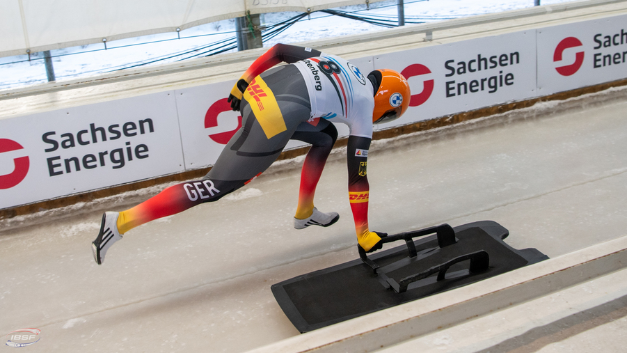 Skeleton Fahrer kurz vor der Abfahrt mit SachsenEnergie Werbung im Hintergrund