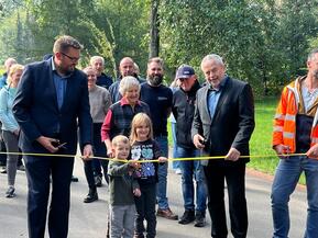 Menschen schneiden ein Sperrband durch 