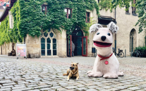 Hund neben XXL Struppi Puppe vor Eingang