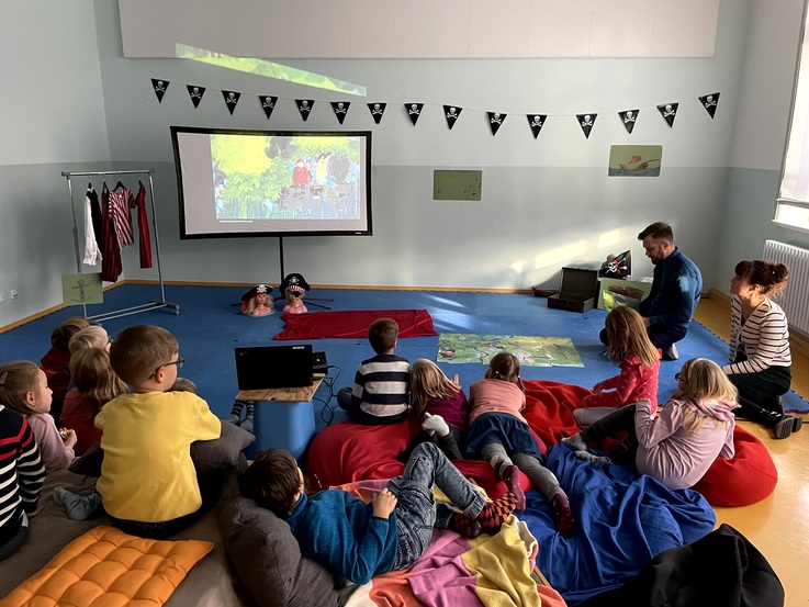 vor einer Kindergruppe wird ein Bilderkino v
