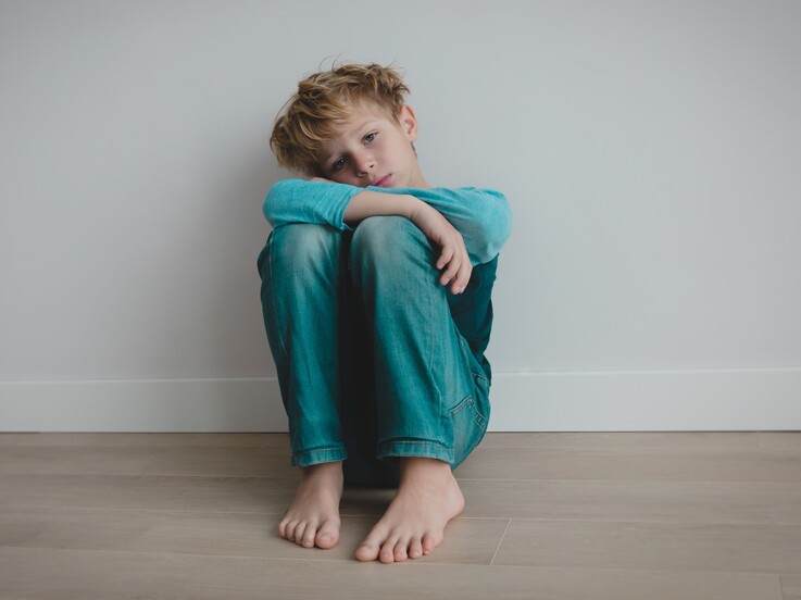 Junge hockt auf Boden