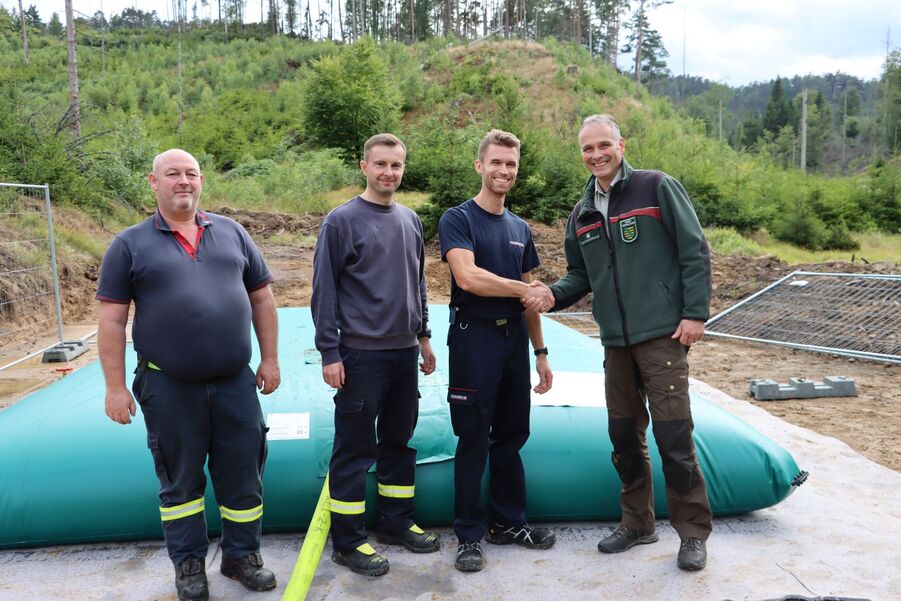 Uwe Borrmeister (re) und Kevin Henker von der Feuerwehr Sebnitz vor der Löschwasserzisterne im Nationalpark Sächsische Schweiz